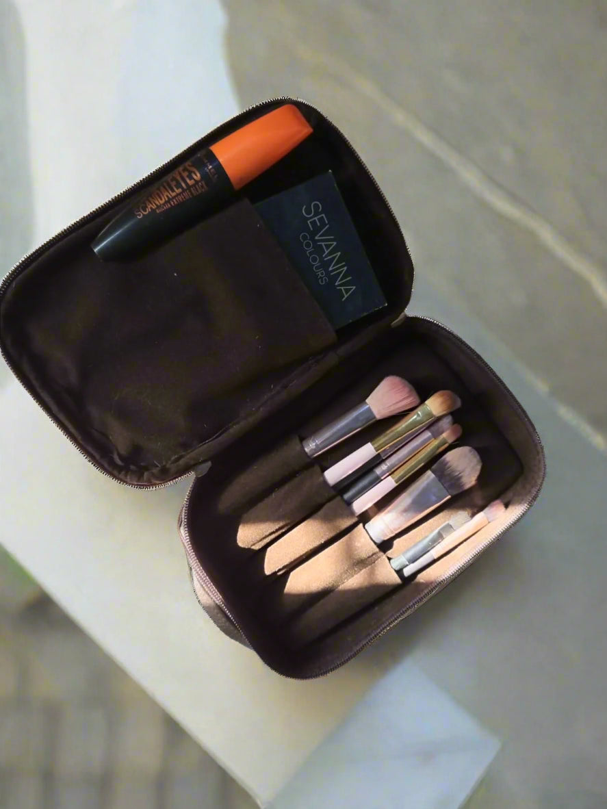 Makeup brush set in an open case on a wooden surface