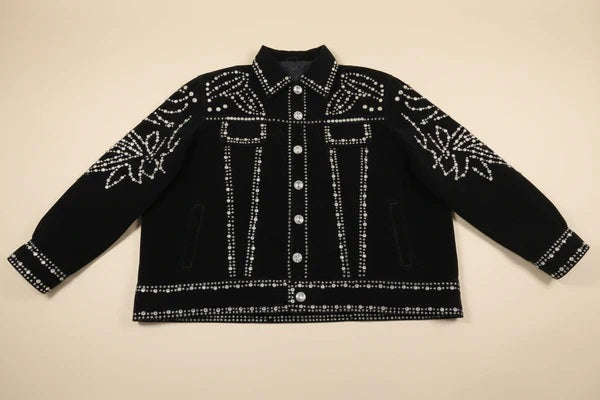 Black jacket with rhinestones and rivets on a beige background