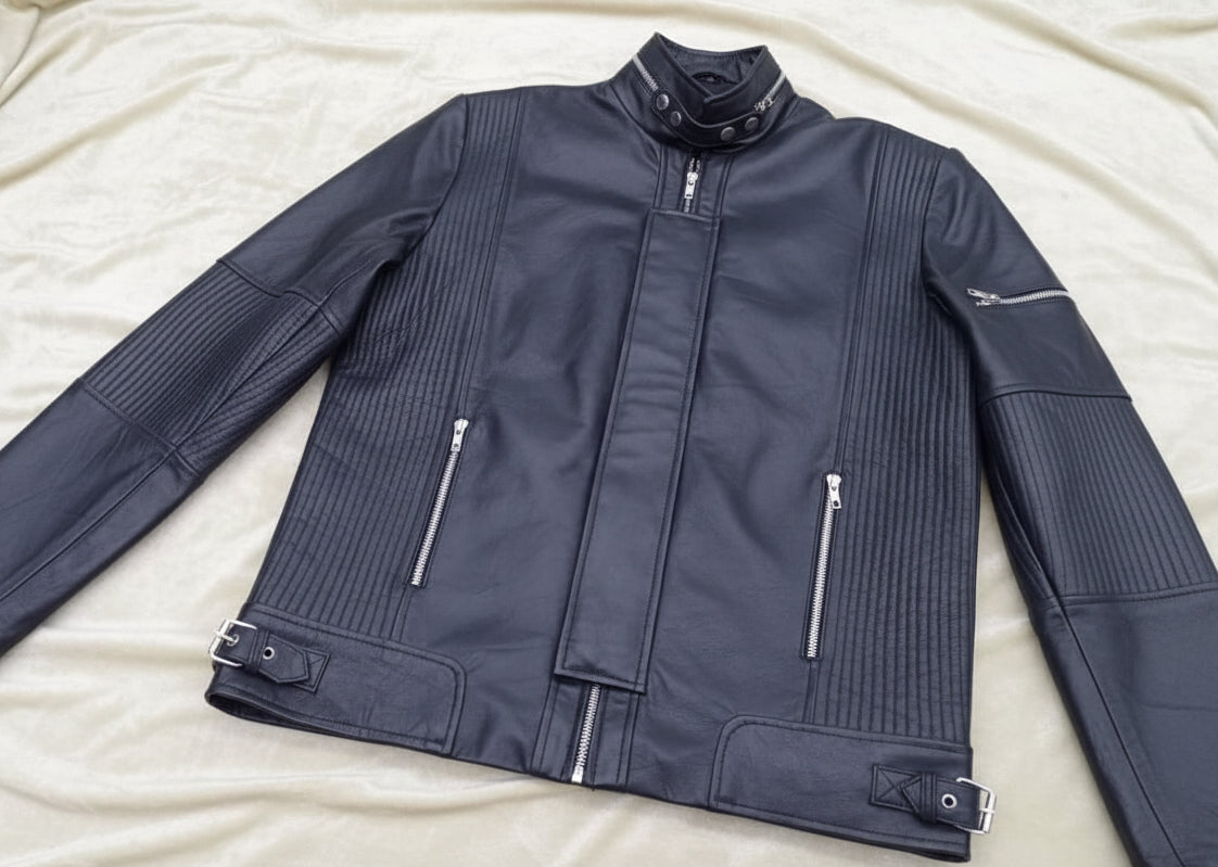 Black leather jacket with zippers on a flat surface