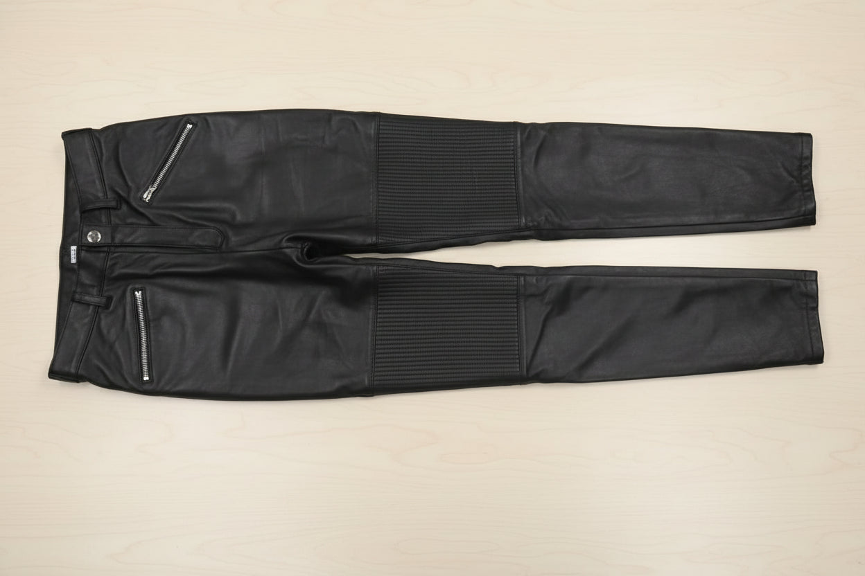 black leather pants with quilted detailing , on a plain suface